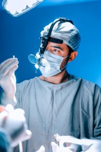 An adult sitting at home gently using prescribed eye drops after surgery, in a well-lit, comfortable living room.
